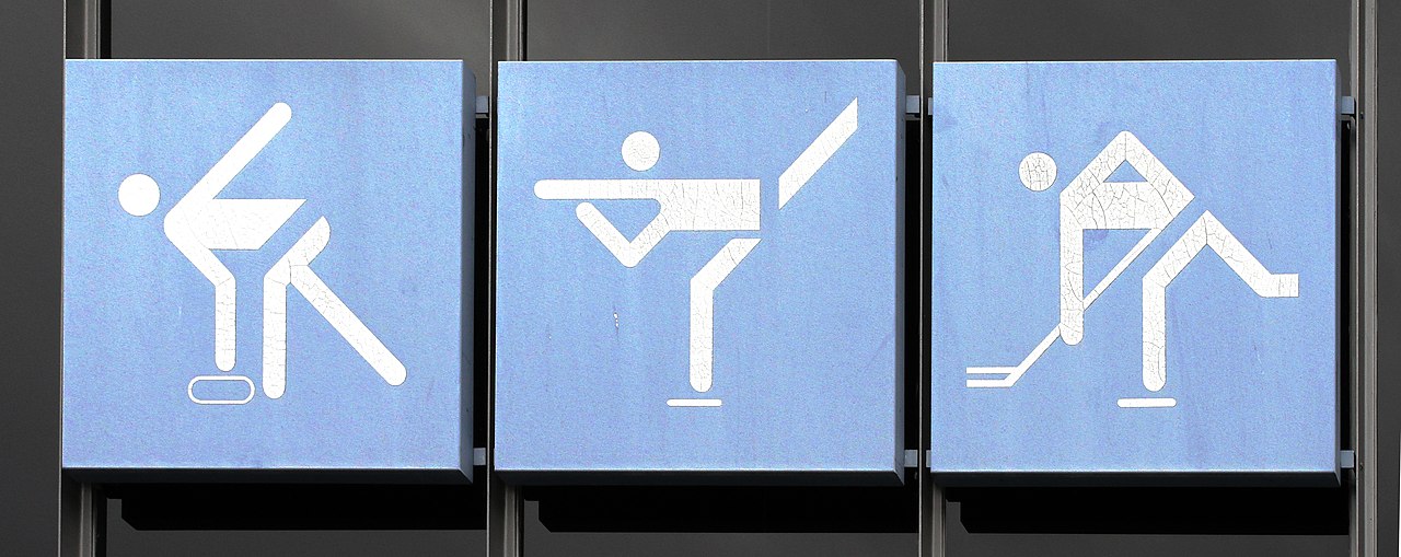 A photo of three signs depicting a stick figure playing sports